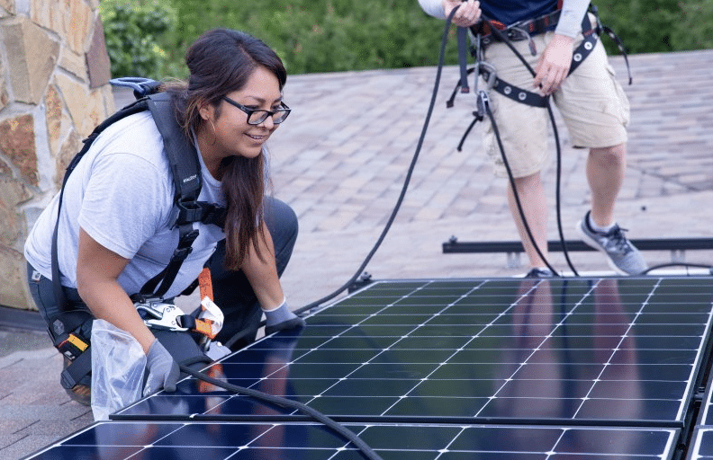 Jan Scott works on a residential solar installation project on a roof in Boulder, Colorado. Photo by Joe DelNero, NREL